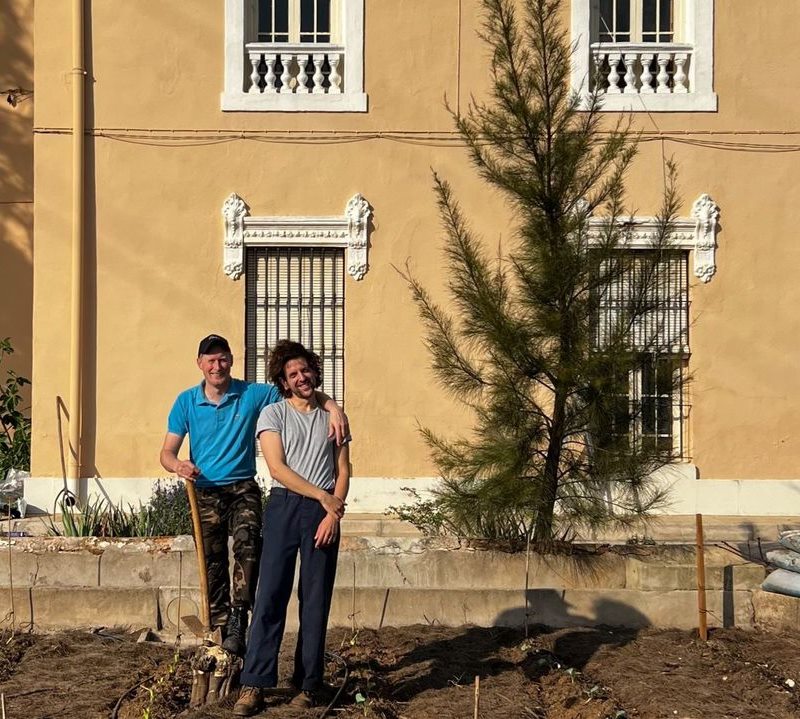 Harm and Antonio in front of the ochre farmhouse, on freshly dug soil